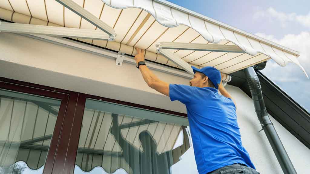 Awning being installed over a window on a Central Coast home