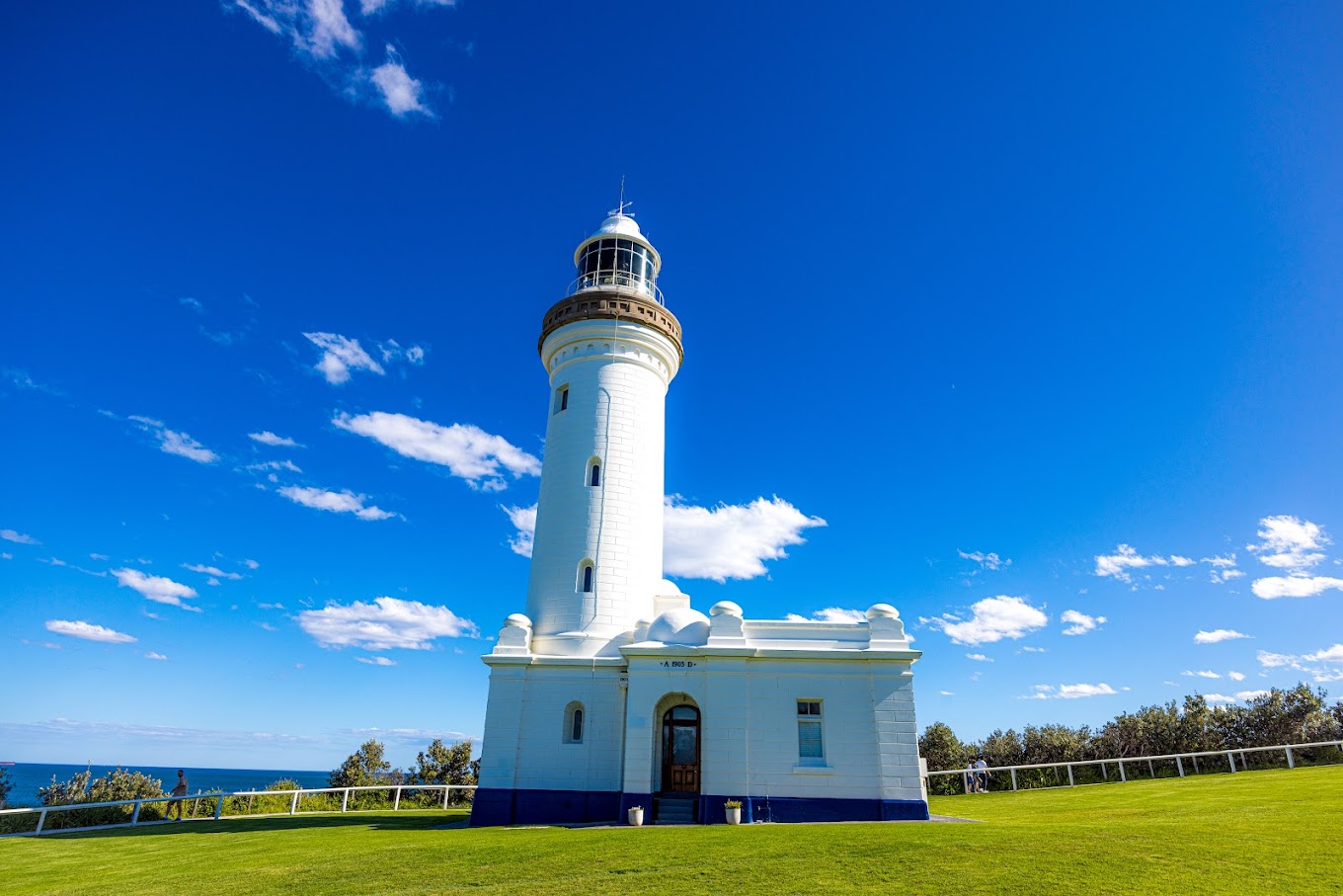 White octagonal tower of Norah Head Lighthouse against a clear blue sky